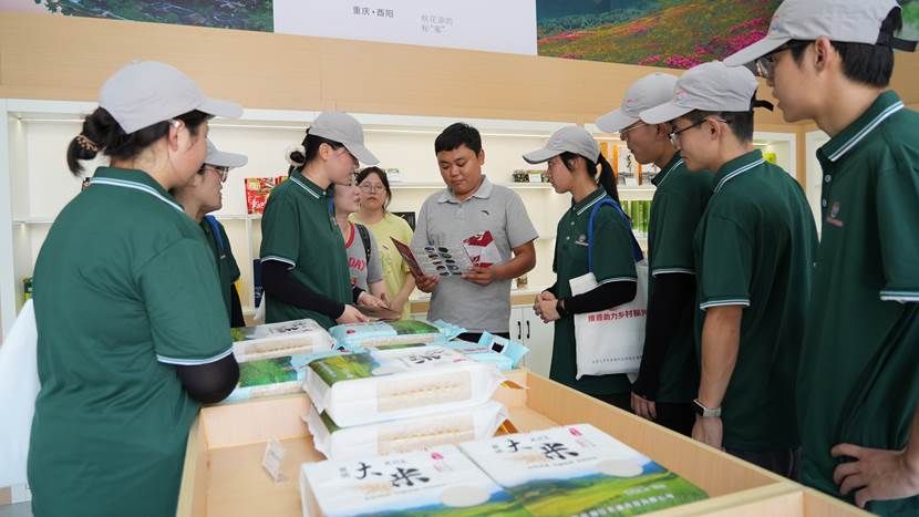 图3 冷鹏向队员们介绍“酉来酉往”特色大米 图3 冷鹏向队员们介绍“酉来酉往”特色大米